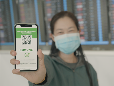 Southeast asian woman show Covid-19 Digital Vaccine passport on Smartphone showing QR code